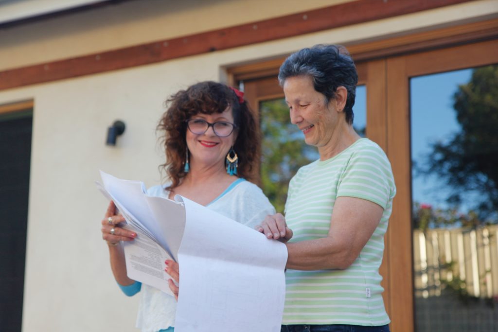 Architect Barbara Cullity (left) and May-Ring Chen (right) looking over the design plans for the solar pergola.